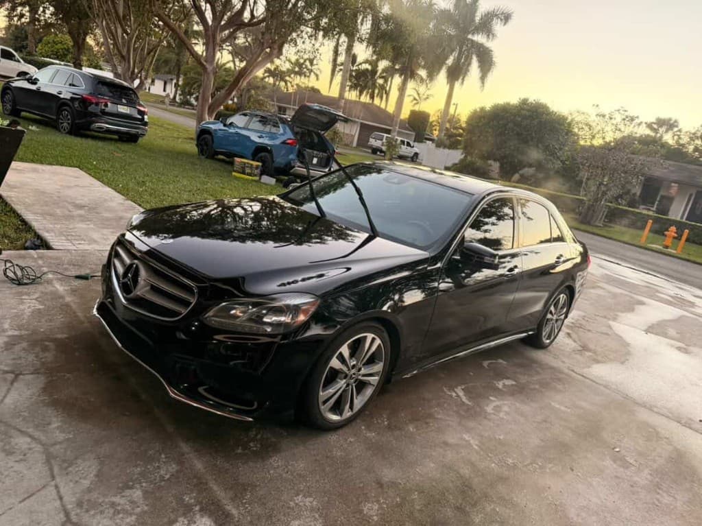 Black Mercedes-Benz E-Class with glossy reflective paint at golden hour after detailing