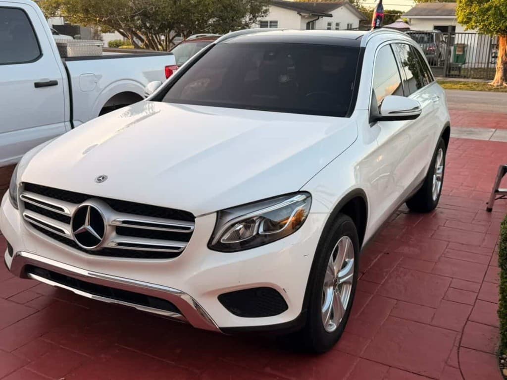 White Mercedes-Benz SUV on a red stamped driveway, front three-quarter view